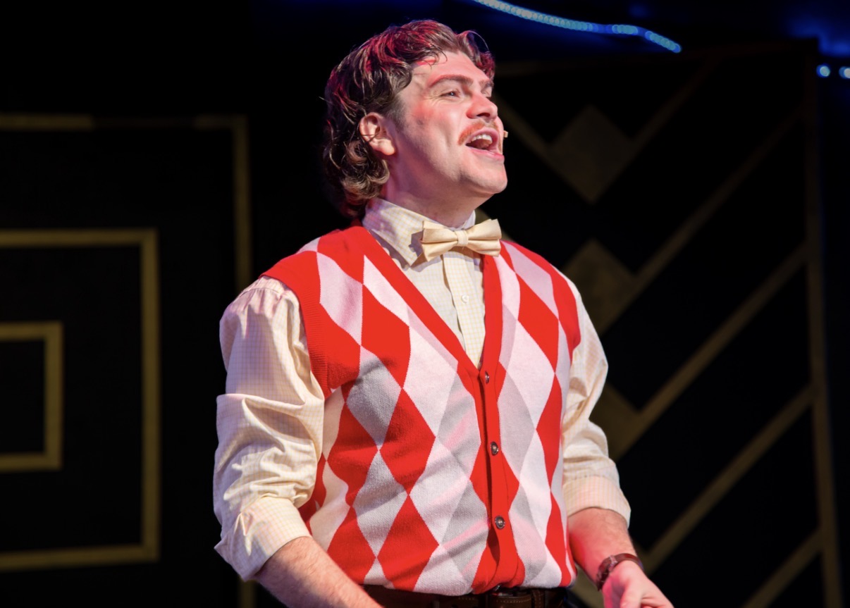 Singing in a red-and-white sweater vest