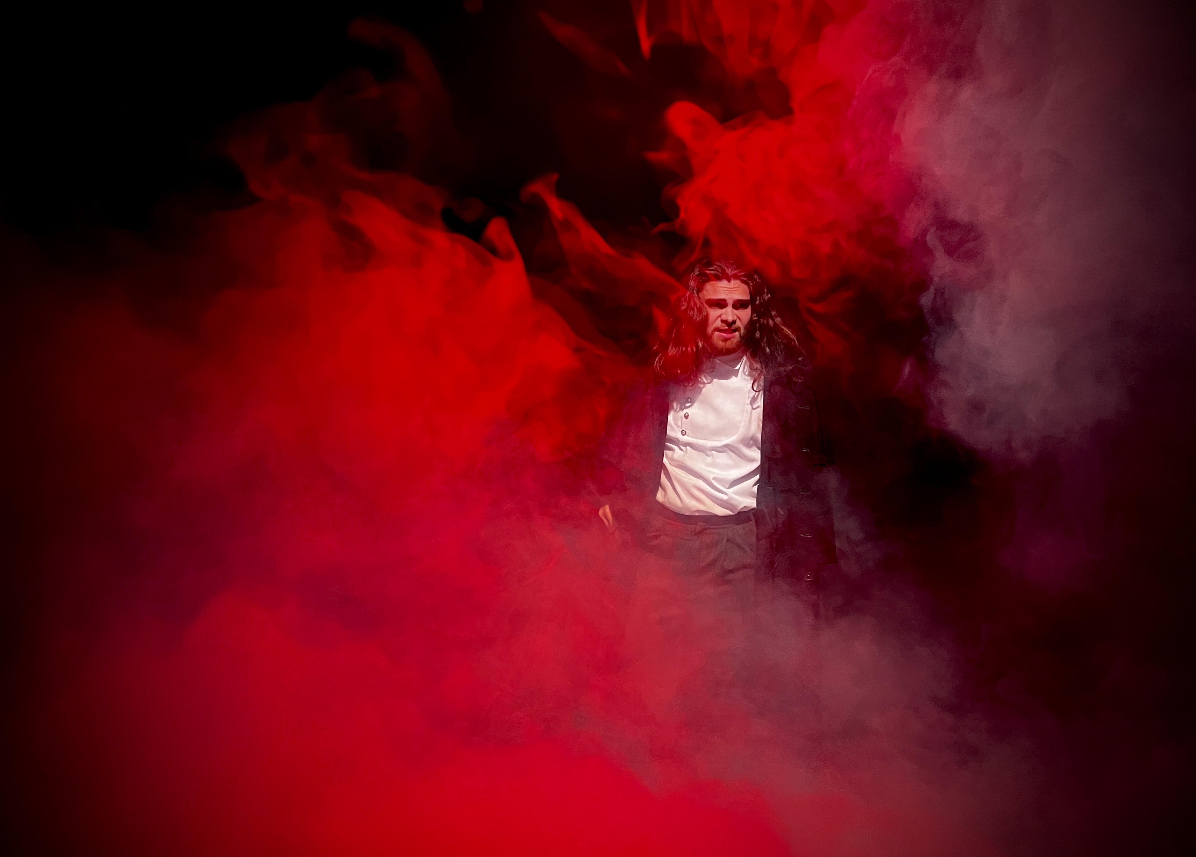 On stage surrounded by red-lit fog