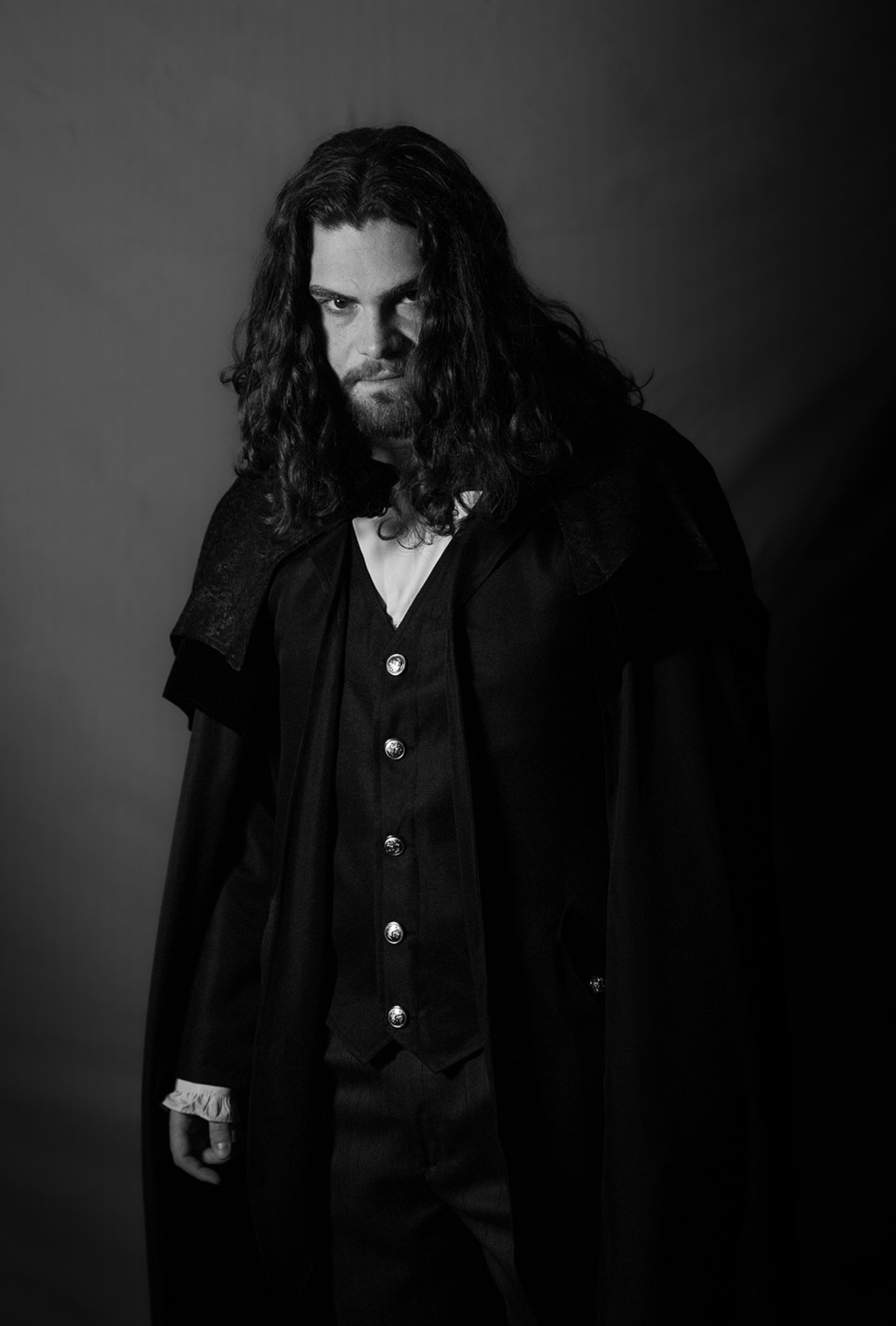 Black-and-white character portrait in a dark coat