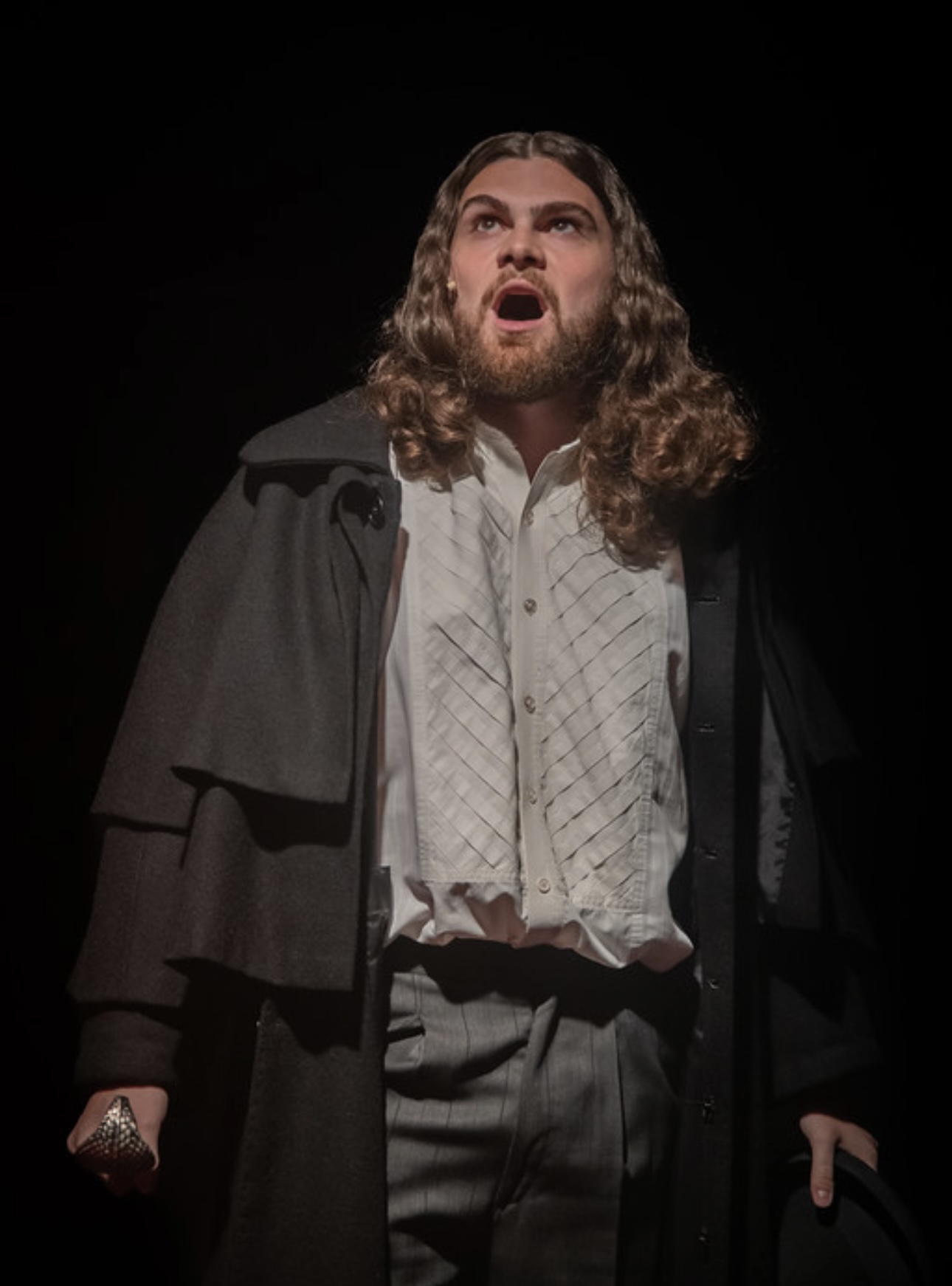 Performing in a dark coat with a cane